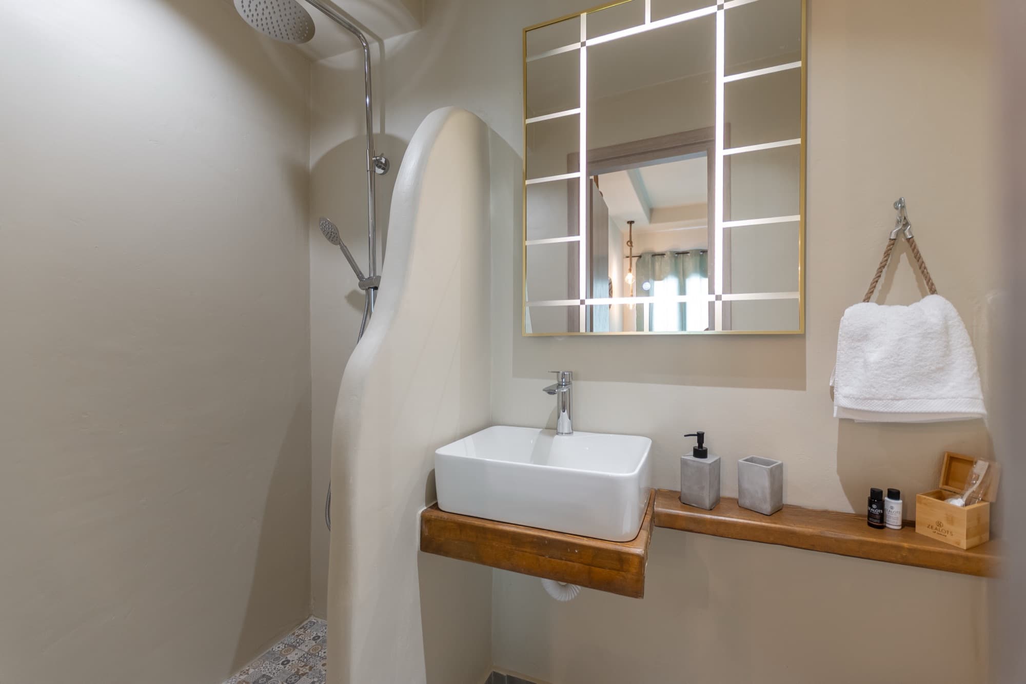 En-suite bathroom with rain shower, vessel sink and gold-framed mirror