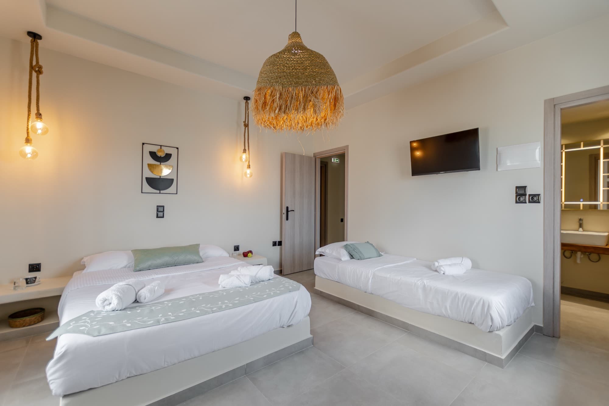 Spacious bedroom with double and single beds, abstract art